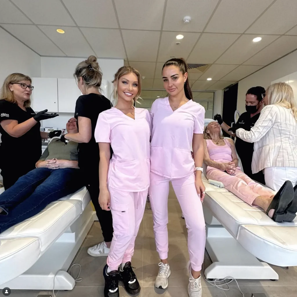 Team of beauty professionals in pink uniforms at a clinic