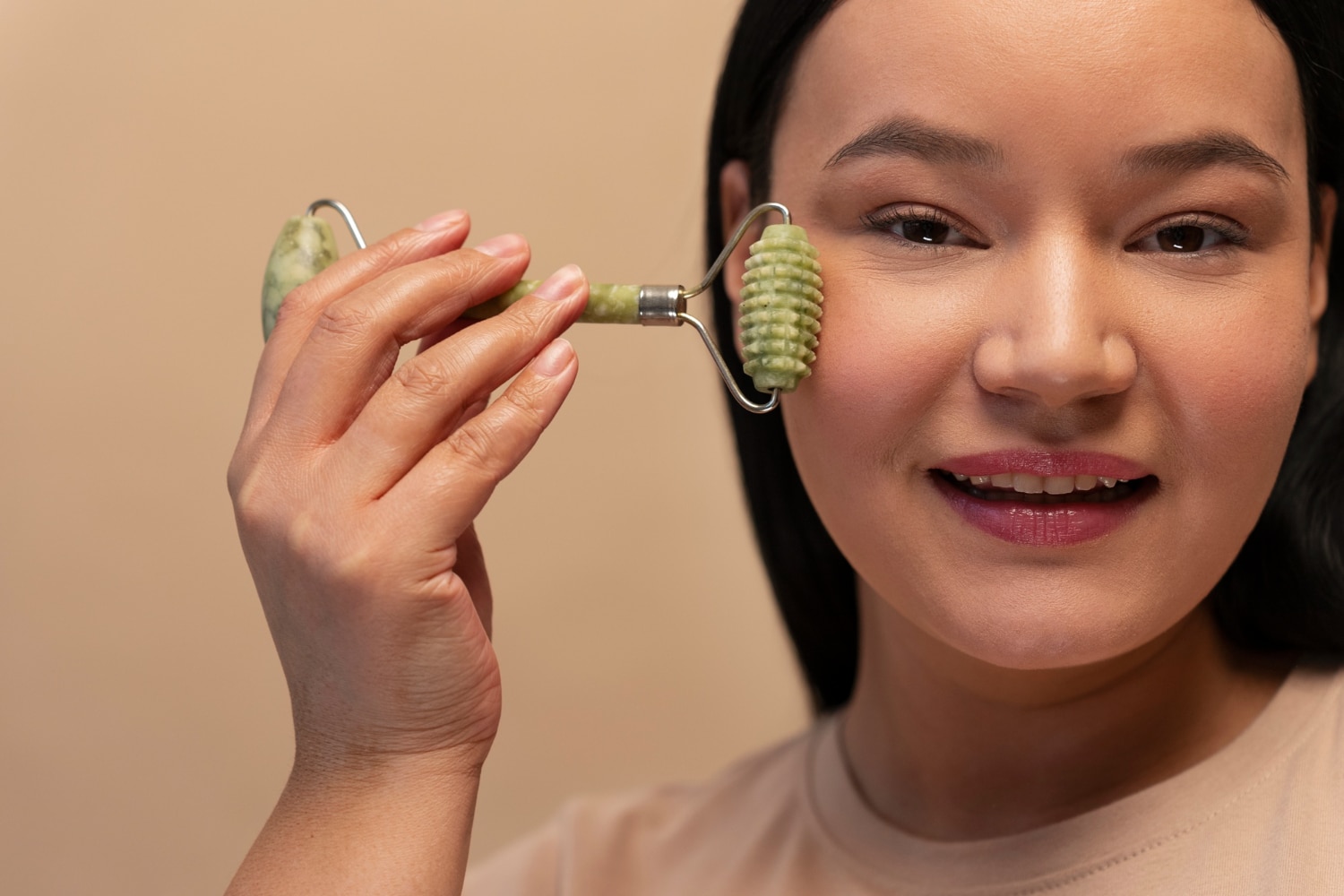 Woman using a jade roller for facial skincare